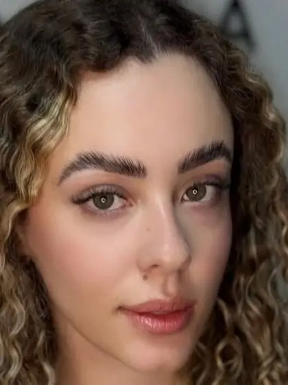 Sobrancelha bem desenhada e cílios em cliente de cabelo cacheado